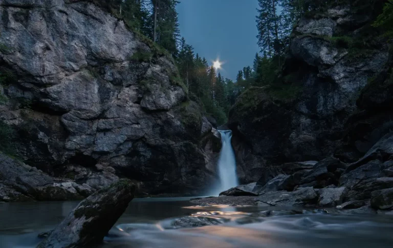 Poza de agua natural con una pequeña cascada al anochecer en un río de Moratalla, Murcia.