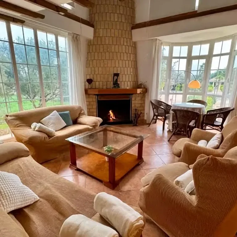 Salón acogedor con chimenea de leña encendida en la Casa Rural Mirasierra, Moratalla.